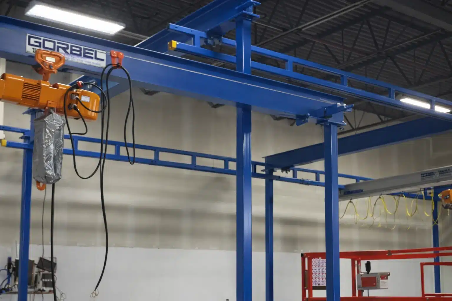 Enclosed track workstation bridge crane for ergonomic material handling
